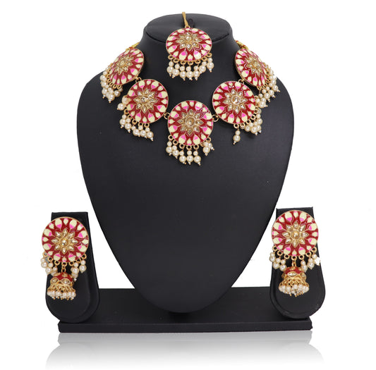 A red-pink choker necklace set with gold-colored accents and pearls, displayed on a mannequin.